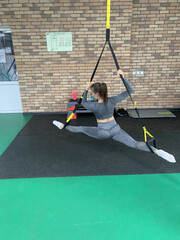 Young Woman in Grey Sportswear Doing Front Split on Tatami Mat in Gym