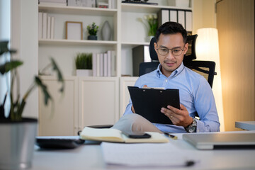 Focused businessman checking reports at his desk in a bright and modern office.