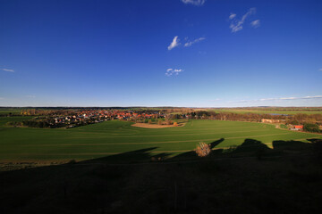 Village fields horizon - panoramic view over green farmland with Weddersleben in the distance