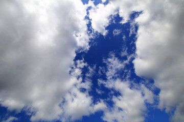Clouds part gently to reveal a deep blue sky framed by soft white edges above