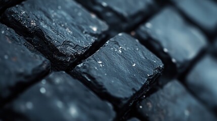 An intricate close-up shot of rugged black stones showcases a captivating texture that evokes a sense of structure, stability, and raw natural beauty in design.