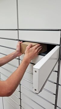 Hands placing a parcel into a secure package locker in a modern delivery hub