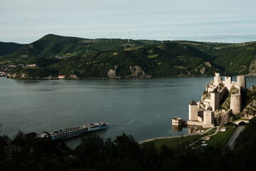 Panoramic scene of Golubac Fortress and Danube River with a cruise ship passing by. A popular tourist destination in Serbia