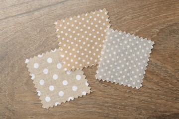 Samples of different fabrics on wooden table, flat lay