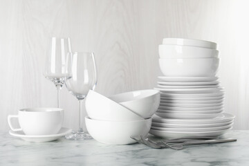 Different clean dishware on white marble table indoors