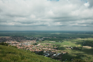 Wide panoramic view of Vrsac and surrounding Serbian countryside under a dramatic cloudy sky in...