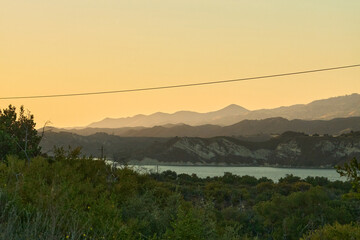 Lake at Sunset with Reflections and Distant Hills
