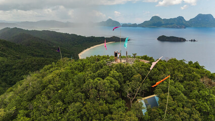 Couple Tourists at Mt. Mansilawit View Deck Overlooking the Island-Dotted Sea of El Nido, Palawan, Philippines