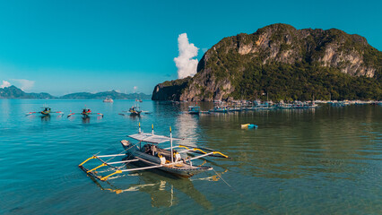 Bangka boats resting in Clear Skies and Peaceful Blue Horizon Over Coastal Paradise of El Nido’s Corong Corong Beach