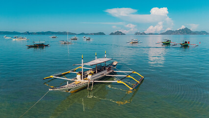 Bangka boats resting in Clear Skies and Peaceful Blue Horizon Over Coastal Paradise of El Nido’s Corong Corong Beach