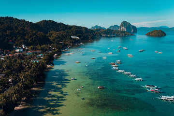 Bangka boats resting in Clear Skies and Peaceful Blue Horizon Over Coastal Paradise of El Nido’s Corong Corong Beach