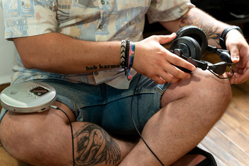 Man using retro headphones and discman while sitting on floor