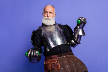 Elderly Man in Medieval Armor Posing Against a Purple Background with Playful Expression