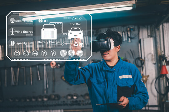 A technician in a workshop uses virtual reality to interact with eco-friendly technology, including solar, wind energy, and electric car battery charging systems.