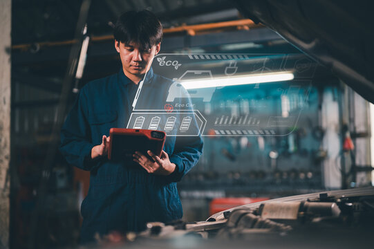 A mechanic uses a tablet with futuristic digital interfaces to analyze car eco data in a dimly lit garage. - Powered by Adobe