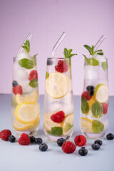 refreshing trio of citrus and berry infused sparkling waters with mint garnish in tall glasses against a subtle purple background, refreshing, inviting, appetizing, desire, soft, clean, artistic