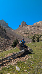 Mountain explorer hiking to the Agujas de Lavasar, surrounded by rock formations and high peaks of the Aragon Pyrenees, in the spectacular Chistau Valley.
