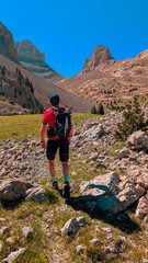 Mountaineer ascending the rocky terrain in the Chistau Valley, with the Agujas de Lavasar in the background and surrounded by high peaks that challenge the adventurer in the Aragon Pyrenees.
