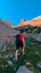 Trekking towards the Agujas de Lavasar, with a mountaineer surrounded by rocks and high peaks, advancing through the challenging rocky terrain of the Aragon Pyrenees, Chistau Valley.