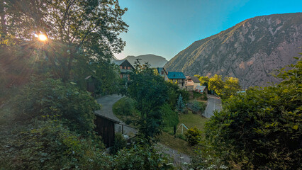 Panoramic view of Saravillo at sunset, with the last rays of sunlight bathing its houses and streets, framed by the majestic mountains of the Chistau Valley, in the Aragon Pyrenees.
