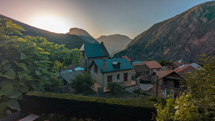 The village of Saravillo at sunset, with golden sunbeams enhancing the beauty of its streets and houses, surrounded by the stunning mountain scenery in the Chistau Valley, Aragon Pyrenees.