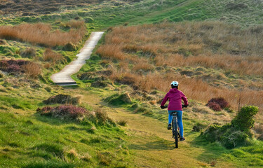 active senior woman riding her electric mountain bike at Mull of Galloway,  the southern most point...