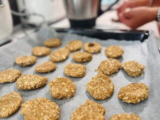 Preparing homemade gluten-free oatmeal cookies on baking tray.