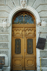 Vintage carved wooden door with decorative wrought iron and architectural details, located in Vrsac town, Serbia. Historical charm and intricate craftsmanship.