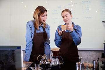 young barista woman making fresh coffee from machine and checking quality in the cafe