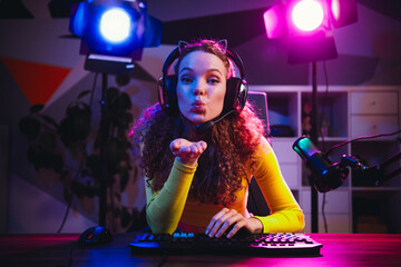 Young woman streaming live videogame session with neon lights in a vibrant home setup