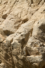 Jagged Tan Rocks with Deep Crevices in Sunlight
