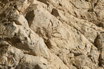 Jagged Tan Rocks with Deep Crevices in Sunlight
