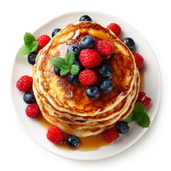 pancakes stack with maple syrup and berries, overhead view, isolated on white background