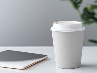 Gray disposable coffee cup on white table