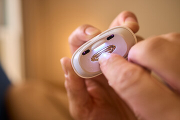 Close-up of an electric nail clipper in hand, modern personal care technology, highlighting compact...