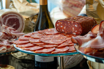 Photo of assorted sausages and sliced meats displayed on a buffet table. The variety of textures...