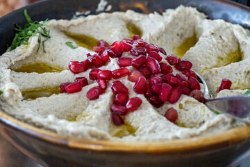 Photo of creamy hummus topped with fresh pomegranate seeds. This vibrant and flavorful Middle...