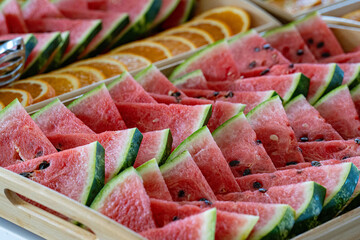Photo of fresh watermelon sliced into juicy wedges. The vibrant red flesh and green rind create a...