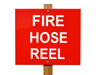 A red rectangular sign with bold black text reading "FIRE HOSE REEL" mounted on a wooden post.