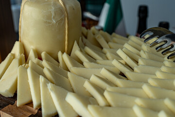 Photo of cheese sliced into wedges and served in a restaurant setting. The presentation highlights...