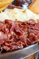 Photo of sliced dried meat served with cheese on a plate. The savory combination highlights gourmet...