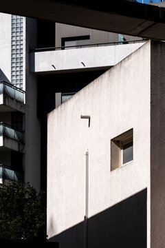 Abstract concrete volume with sharp sunlit edge and shadow division, showing minimalist architecture and spatial rhythm perfect for clean graphic background use
