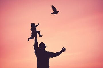 Silhouette of Father Holding Child Against Colorful Sunset Sky