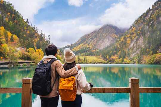 Young couple tourist looking at beautiful autumn scenery landscape at jiuzhaigou national park in Sichuan, China