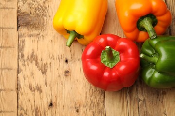 Fresh colorful bell peppers on wooden table, flat lay. Space for text