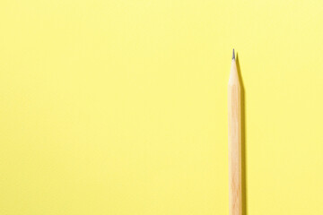 One graphite pencil on yellow background, top view. Space for text