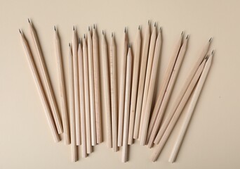 Many graphite pencils on beige background, flat lay