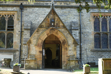 Ashford in the Water, Derbyshire / England - June 20 2025: Entrance to a traditional stone church...