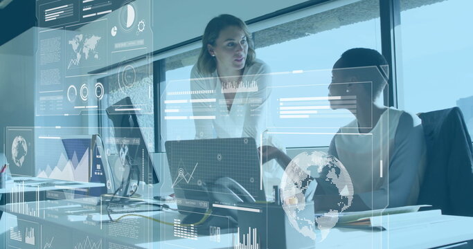 Collaborating mid adult women examining holographic panels beside laptops in office, with notebook - Powered by Adobe