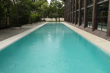 Outdoor swimming pool and green plants near building at luxury resort